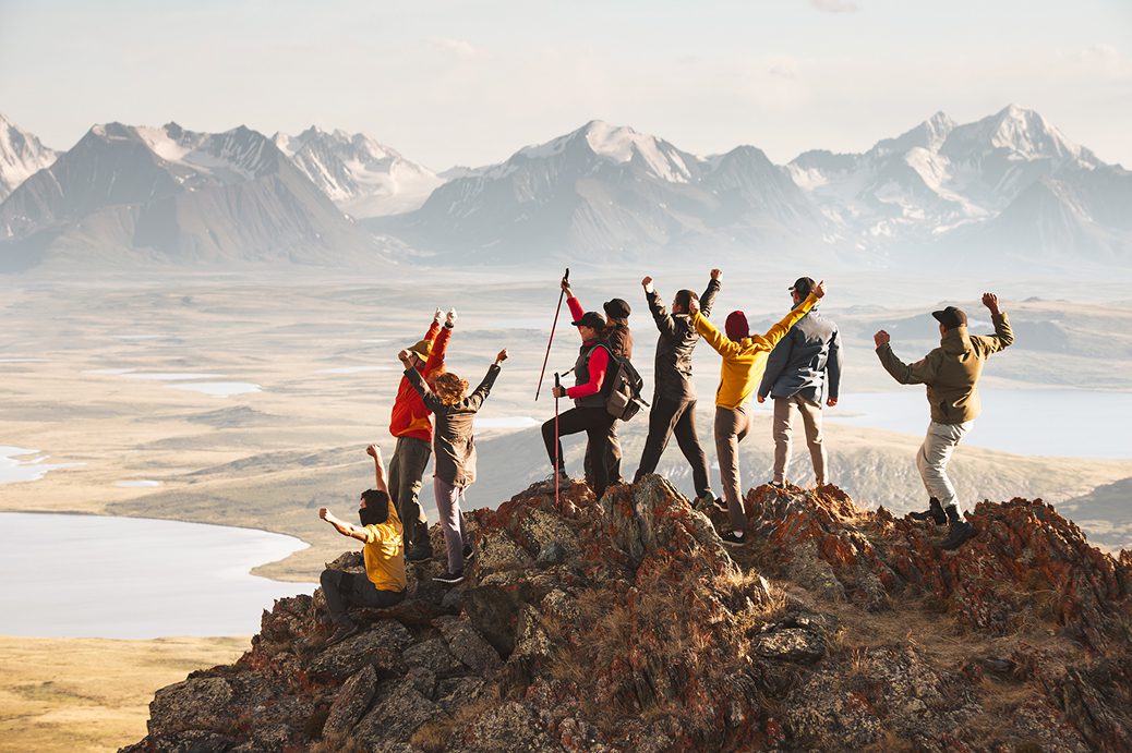 Group celebrating atop a mountain peak