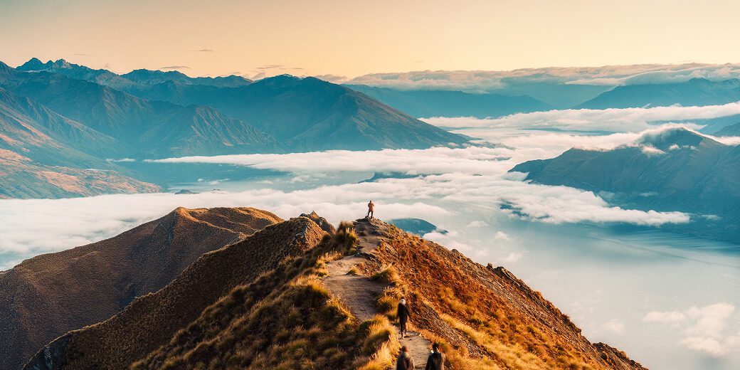 Mountain peak with hikers and clouds