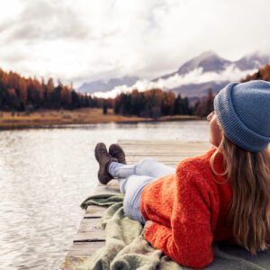 Woman relaxing on lakeside dock